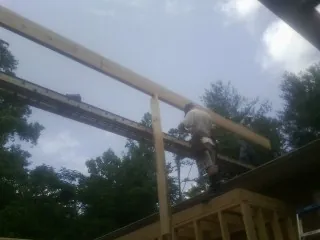 Carpenter setting a ridge beam over a new addition frame — Ice Dam Removal by Roofing Brothers in Cathedral City