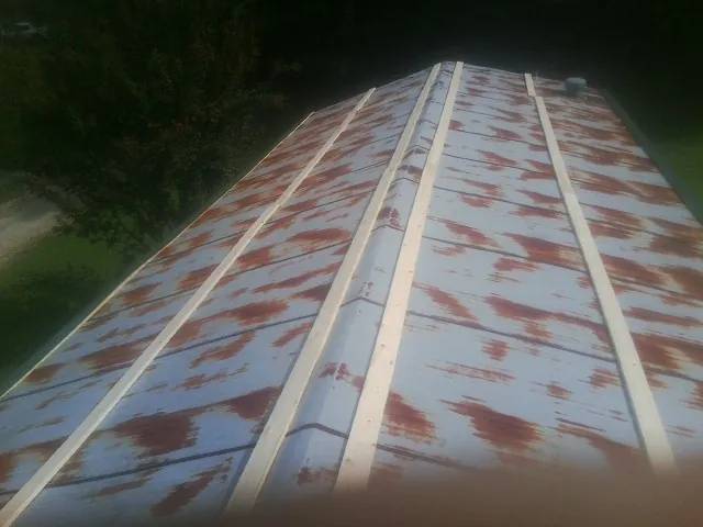 Rusted metal roof panels with new wood purlins before replacement — Storm Damage Roof Repair in Cathedral City by Roofing Brothers